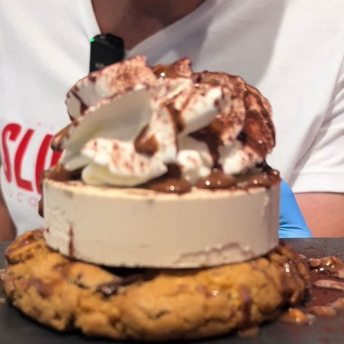 Dolce Sliceroll su biscotto con panna e caramello servito su lavagna nera