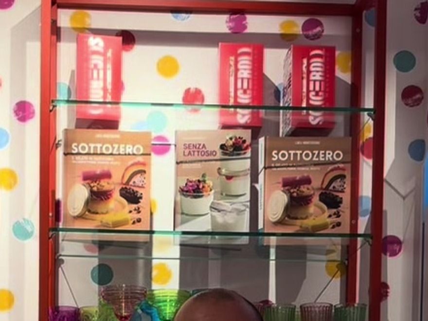 Scaffale del punto vendita Sliceroll con i libri del gelato e pareti a pois